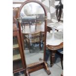 A mahogany and brass mounted Beidermeier style arch top cheval mirror, on paw feet and castored
