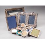 A modern silver double photograph frame with embossed decoration, ten other silver photograph frames