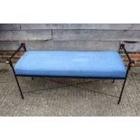 A wrought metal framed window seat with loose seat cushion, on stretchered supports, 52" w x 21"