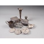 A silver milk jug, a silver toast rack, a silver tea strainer, a silver bonbon dish, a silver