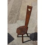 A 19th century Welsh spinning chair with carved back and seat panel, on four supports