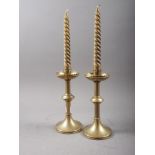 A pair of ecclesiastical style turned brass candlesticks, on circular bases, 8 1/4" high