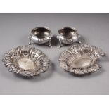 A pair of silver salt cellars with embossed decoration, on three supports, a pair of bonbon dishes