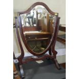 A mahogany shield-shape swing frame toilet mirror, on skeleton stand, 15" wide x 23" high