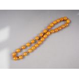 An 'amber' coloured bead necklace with metal spaces, the barrel shaped beads 14mm wide, total weight