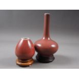 A Chinese sang de boeuf sprinkler vase, on hardwood base, 6 3/4" high overall, and a similar egg-