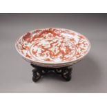 A Chinese iron red porcelain shallow dish, decorated dragons and clouds, six-character mark to base,