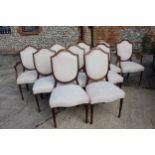 A set of ten mahogany dining chairs with arched tops, upholstered in a cream patterned brocade (8+2)