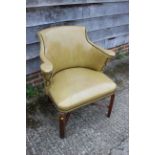A studded armchair, upholstered in a mustard leather, on stained as walnut cross stretchered