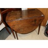 A provincial mahogany oval drop leaf table, on six square taper supports, 35" wide x 50" deep x