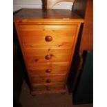 A pine chest of five drawers with knob handles, on bun feet, 18" wide x 15 1/2" deep x 38" high