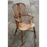 A Windsor farmhouse elbow chair with panel seat and crinoline stretcher