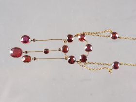 A yellow metal and garnet pendant necklace