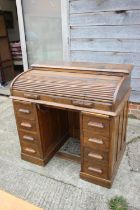 A 1930s American oak roll top, double pedestal desk, fitted nine drawers, 42" wide x 27" deep x