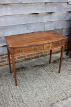 A bowfront side table, fitted three drawers, on square taper supports, 36" wide x 18" deep x 29"