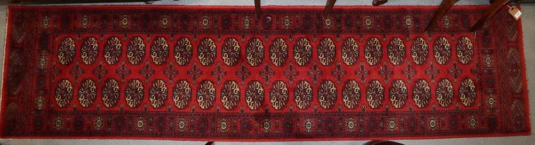 A Bokhara style runner with thirty-six guls in traditional shades, 25" x 106" approx
