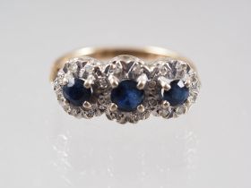 An 18ct gold sapphire and diamond triple cluster ring, size G, 3.6g