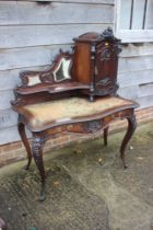 A late 19th century French carved walnut serpentine desk, fitted raised back, mirror panel and