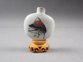 A Chinese porcelain snuff bottle, decorated crickets, seal mark to base, on wooden stand, 2 1/4"