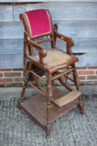 A child's ash metamorphic high chair/table with back upholstered in a red velour