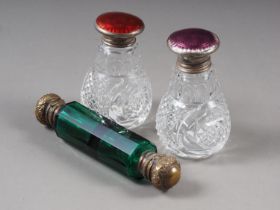 Two silver end guilloche enamelled cut glass scent bottles, and a green glass and brass mounted