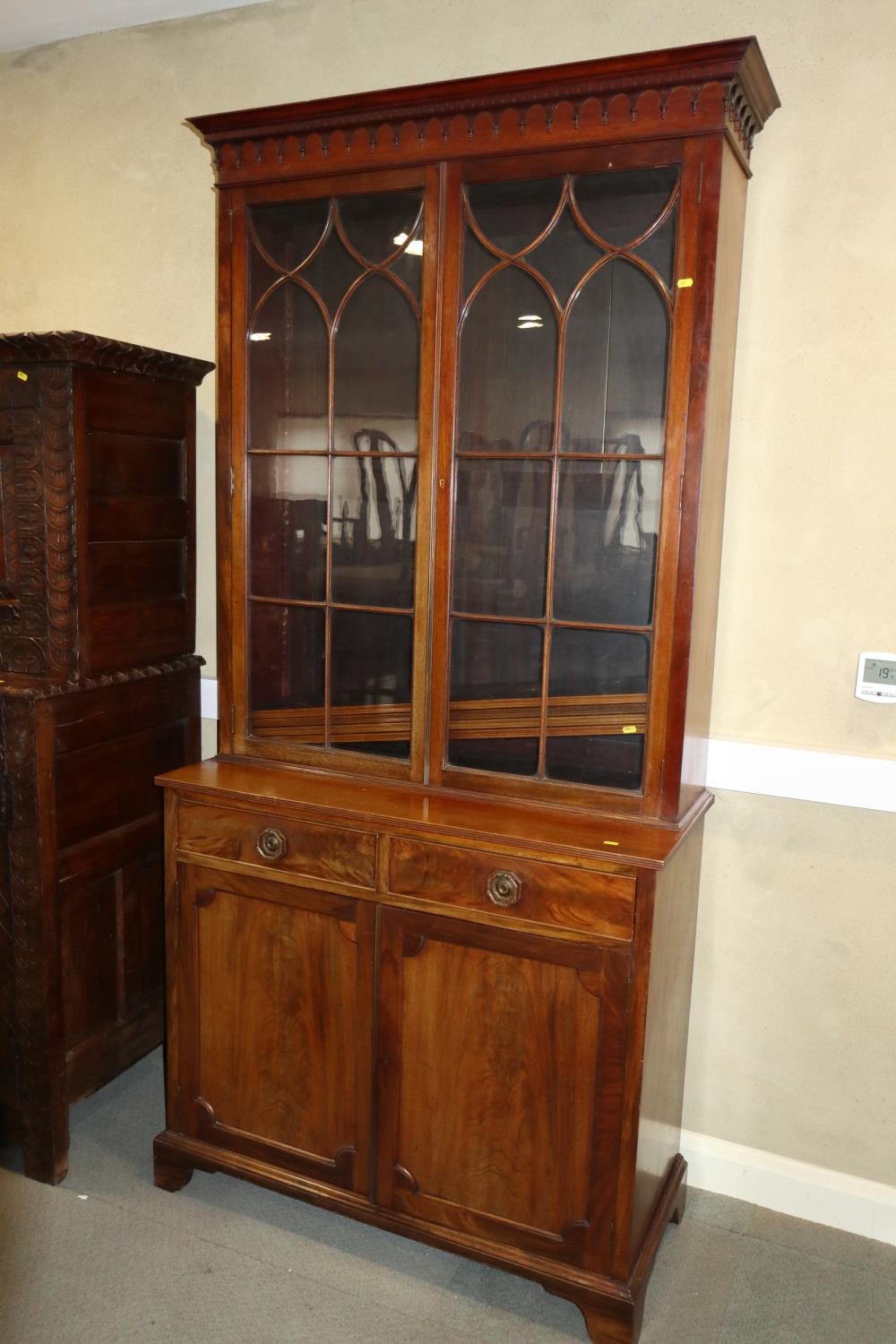 A 19th century mahogany bookcase, the upper section enclosed Gothic lattice glazed doors, over two