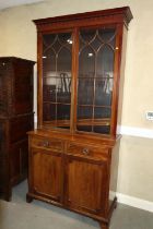 A 19th century mahogany bookcase, the upper section enclosed Gothic lattice glazed doors, over two