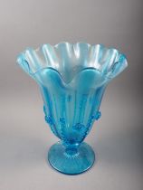 A blue glass pedestal vase with shaped flared rim and applied decoration, 14 1/2" high