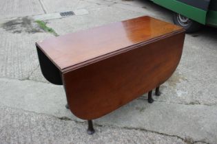 A Georgian mahogany drop leaf dining table, on turned supports and figured pad feet, 48" wide x