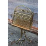 A late Victorian brass wirework magazine stand, on tripod splay supports, 35" high