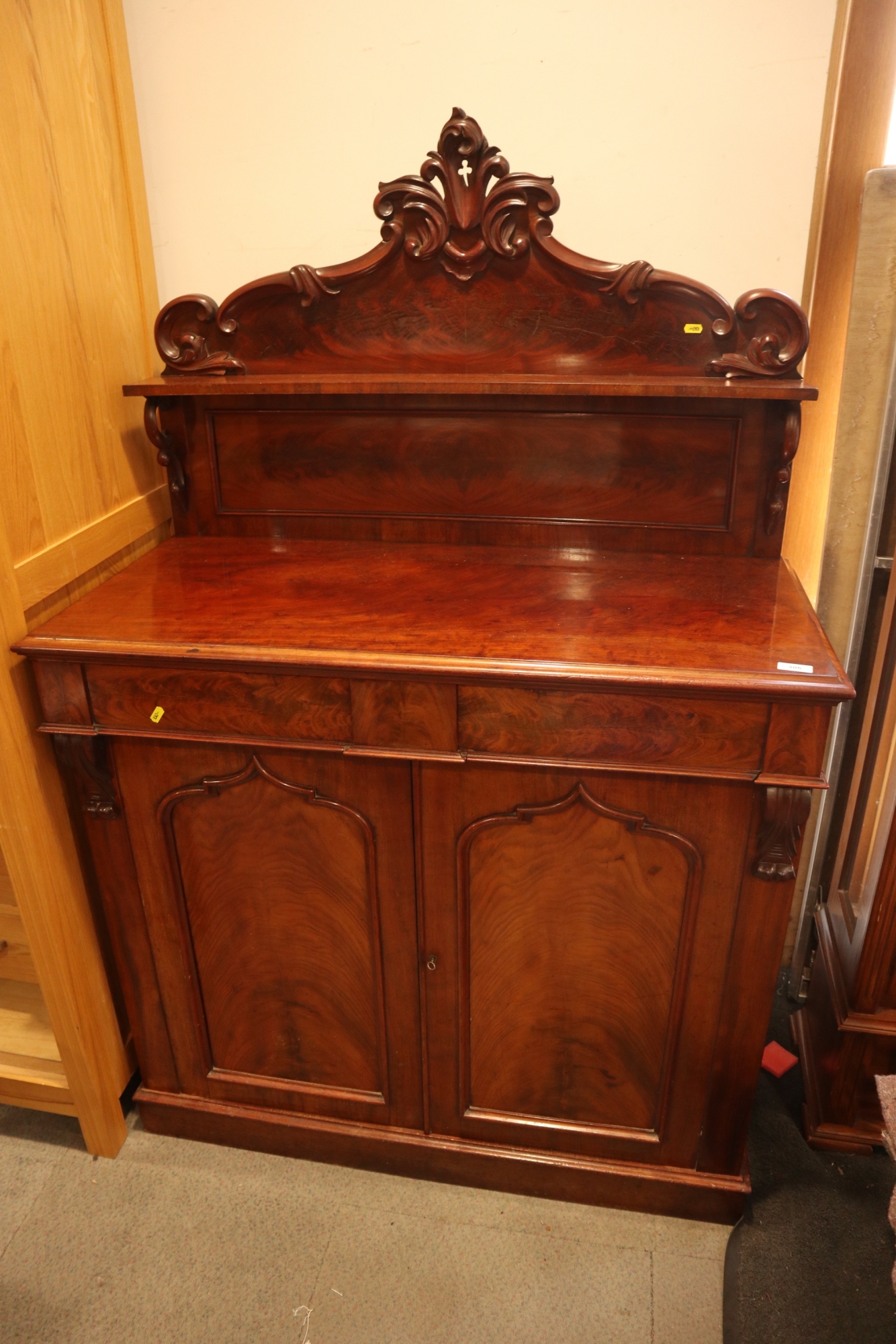 A late 19th century figured mahogany ledge back chiffonier, fitted shelf over two drawers and