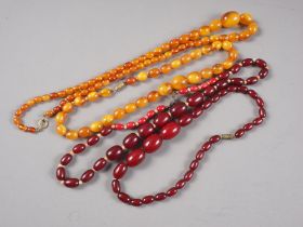 An Art Deco cherry amber Bakelite bead necklace, 15" long, 21.7g, a made-up cherry amber Bakelite