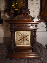 A Junghans mahogany cased mantle clock with tower finial, swags and half bobbin turned columns and