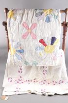 Two early 20th century American patchwork quilts, one with floral design in multiple fabrics, the