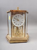 A Kundo anniversary clock, in glass and brass hexagonal case, 10" high