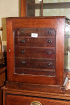 A collector's polished as mahogany chest of six long graduated drawers with glazed panel door and