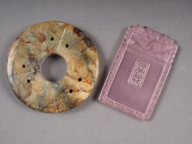 A Chinese hardstone disk with central piercing, 2 3/4" dia, and a pink Peking glass rectangular