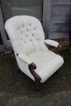 A Victorian showframe armchair, button backed in a magnolia brocade, on turned supports