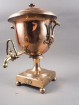 A copper and brass samovar with masks and handles, on a square base and bun feet, 16" high
