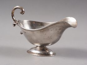 A silver sugar basket, on oval foot, 5.2oz troy approx, and a silver sauce boat with scroll