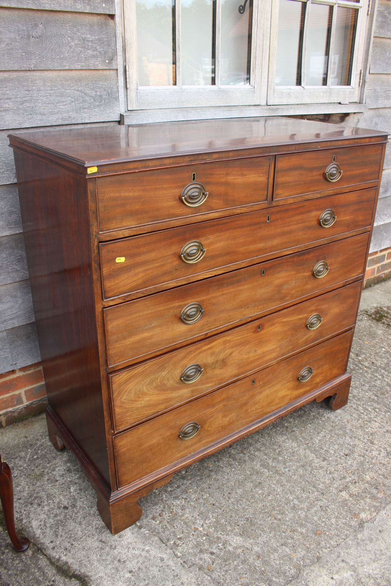 A late Georgian mahogany chest of two short and four long graduated drawers with stamped brass