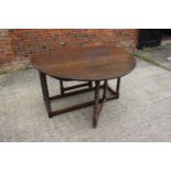 A 19th century oak drop leaf dining table, on bobbin turned and stretchered supports, 50" wide x 61"