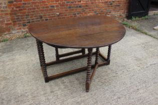 A 19th century oak drop leaf dining table, on bobbin turned and stretchered supports, 50" wide x 61"