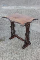 A late Victorian figured walnut shape top occasional table, on carved panel end supports, united