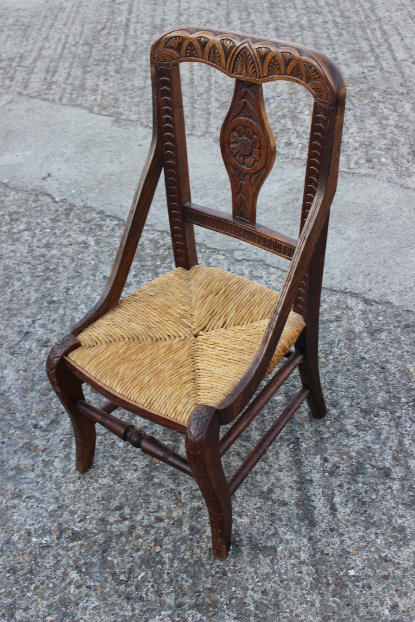 A child's provincial carved hardwood side chair with rush envelope seat, on cabriole stretchered
