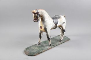 An early 19th century carved wood and painted model horse, on base board, 15" high (formerly a