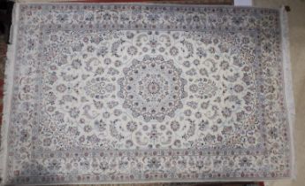 A Nairn wool and silk detailed fine wool rug with all-over scroll design, on a cream ground in