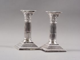 A pair of silver Corinthian column candlesticks, on stepped bases, 6 1/4" high