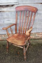 A Windsor farmhouse lathback elbow chair with panel seat on turned and stretchered supports