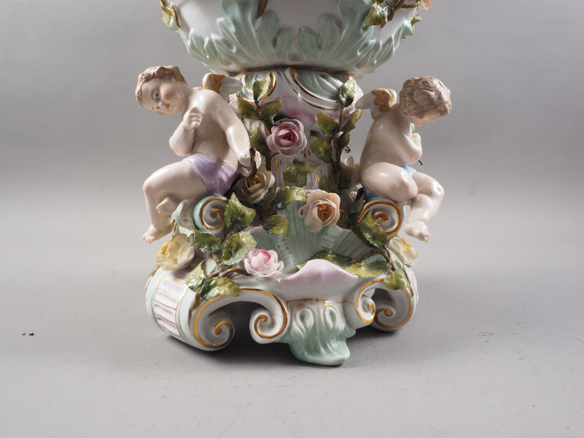 A Continental porcelain table centre with relief putti and flower decoration, on scrolled - Image 4 of 4